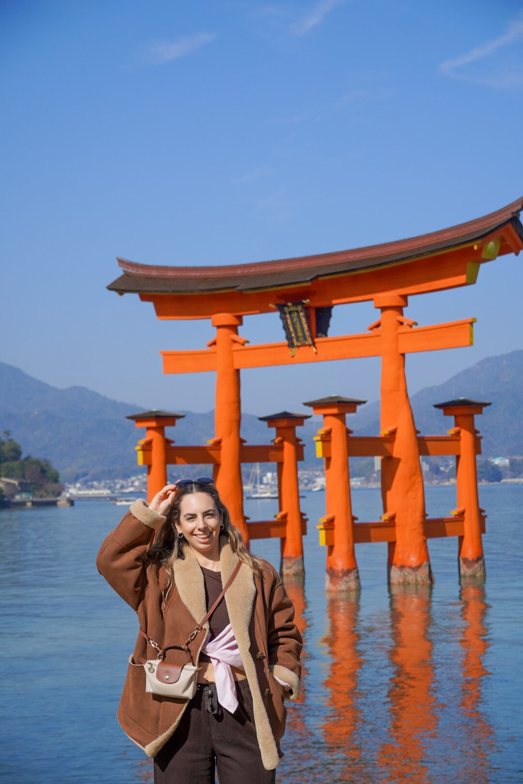 Alba in front of the floating torii gate in Miyajima, Japan